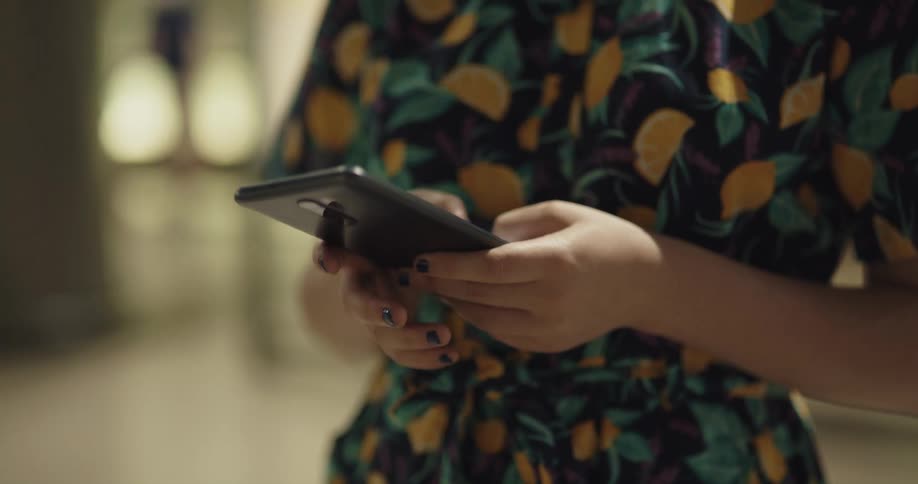 A woman is in a building and texting on a cell phone