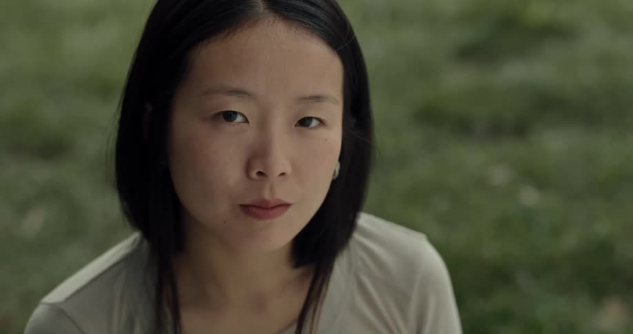 An asian woman turns her head and smiles