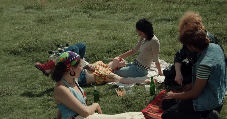 A group of friends are hanging outdoors together and drinking beer