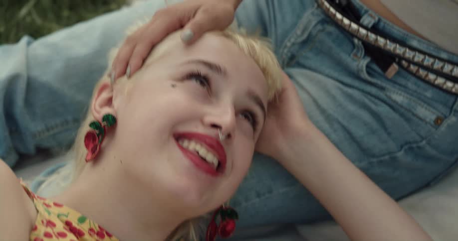Boyfriend and girlfriend are sitting on a blanket in the grass