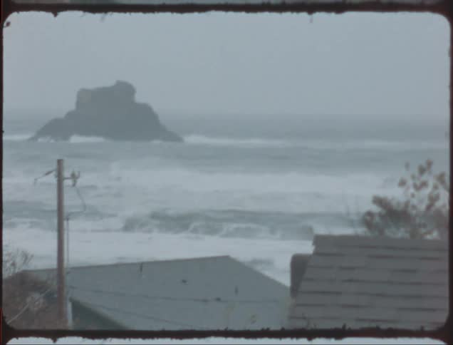 A thunderstorm rages on the coast making waves choppy