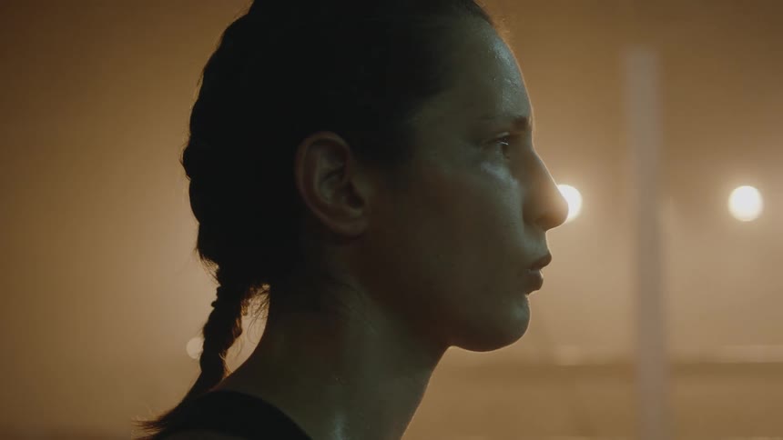 A woman looks forward while sweating in the gym