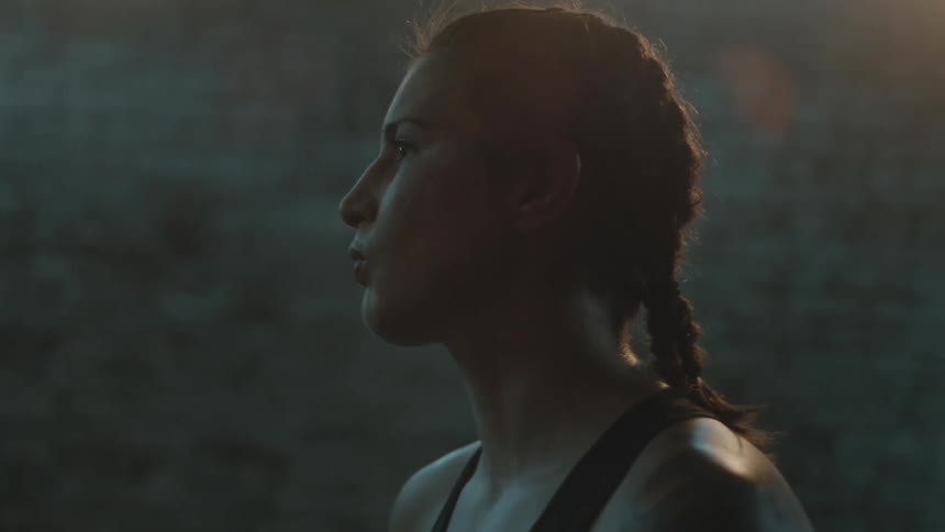 Woman wearing sports bra stand in dimly lit room