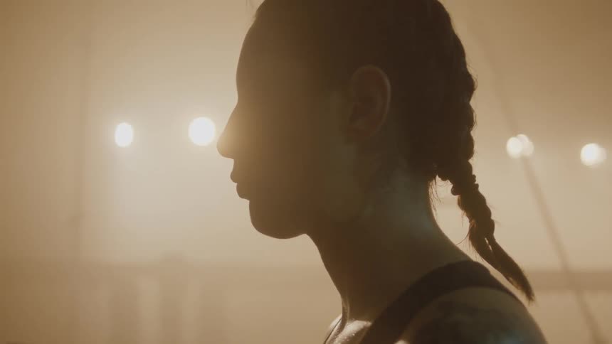 The silhouette of an athletic woman standing in profile