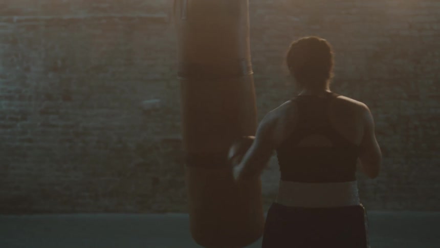 A woman is boxing in the gym