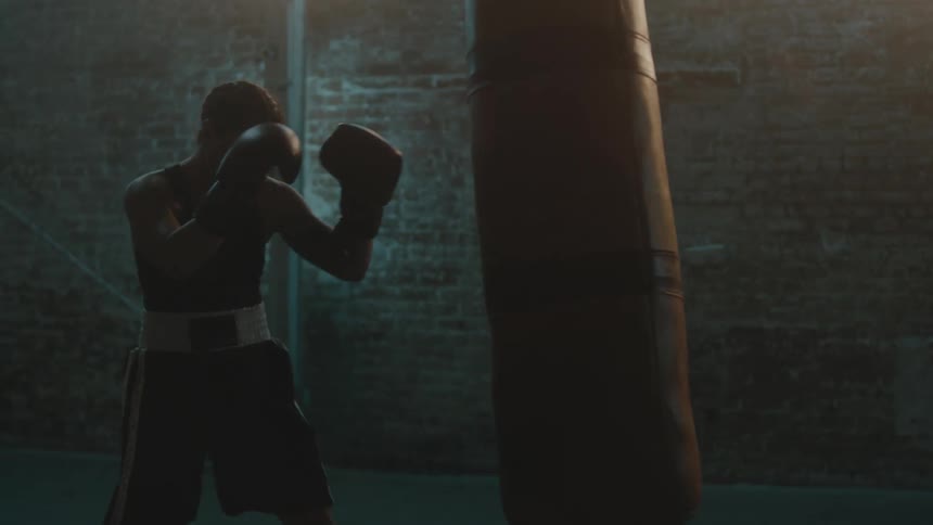 A woman is hitting a punching bag indoors