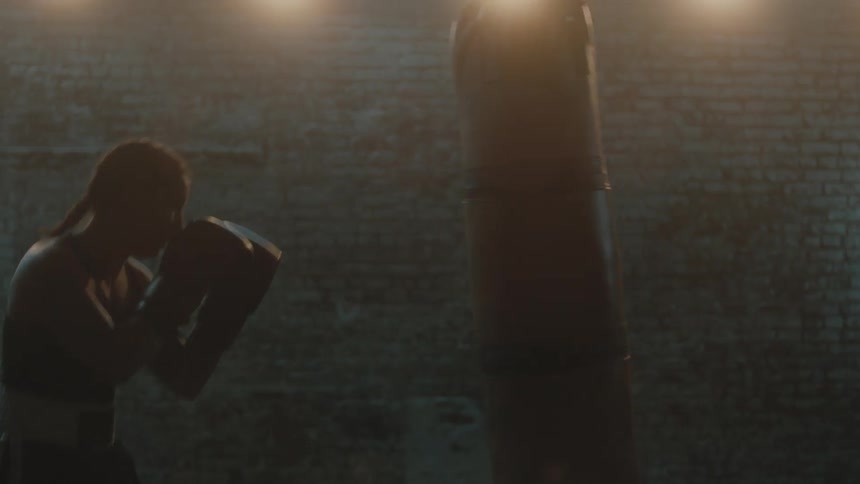 A woman is boxing by herself in a building