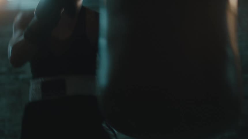 A woman is boxing alone in a room and training