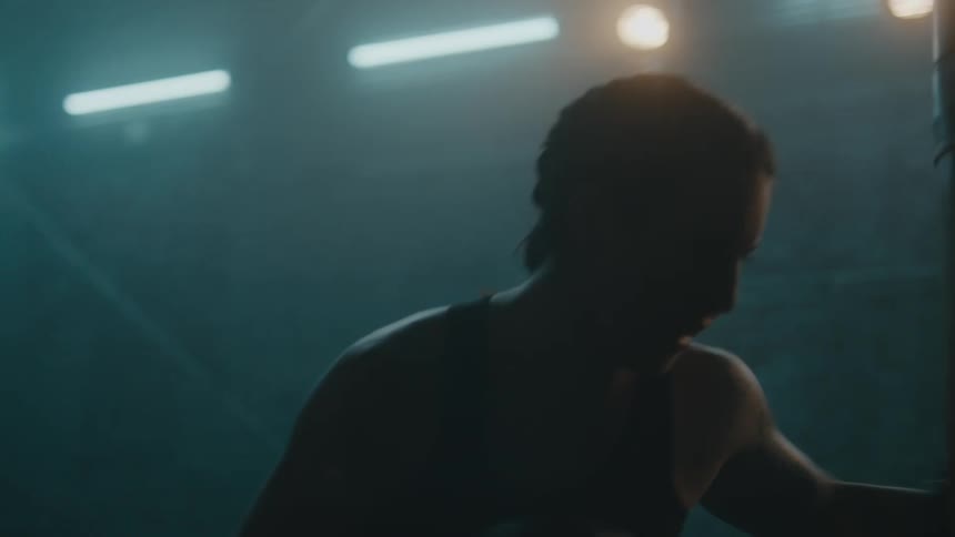 A female is boxing by herself in a room