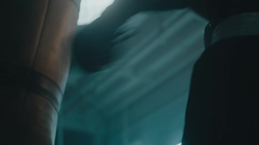 A person is boxing by themselves in a room