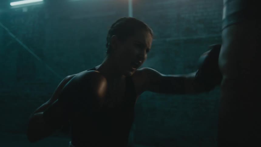 A woman is boxing by herself in a building