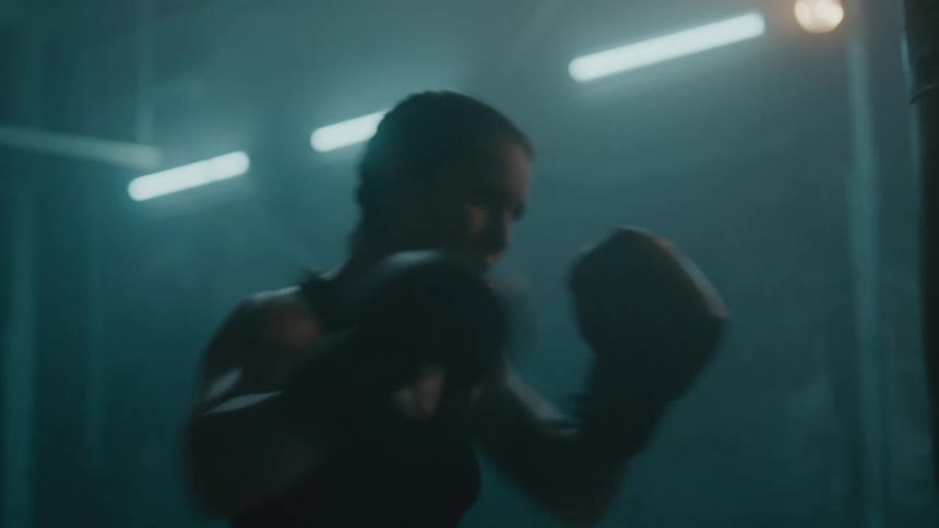 A woman is punching the heavy bags