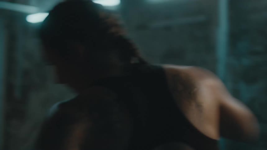 A woman is boxing by herself indoors