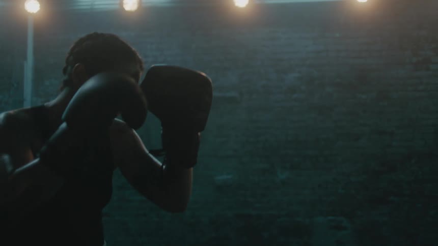 A female boxer hits a punching bag in the gym