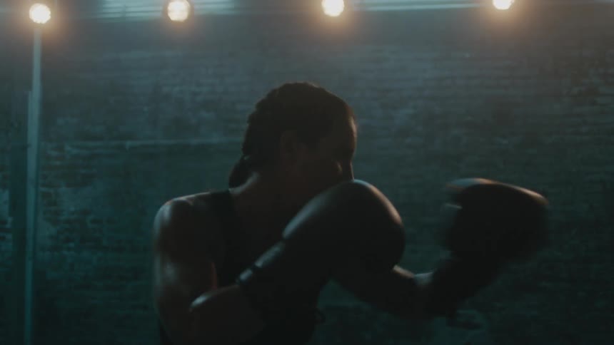 A woman is boxing by herself in a room