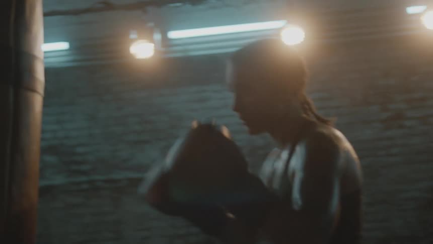 A woman punches the heavy bag in the gym
