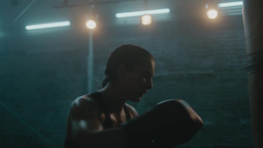 A woman is hitting a punching bag while boxing