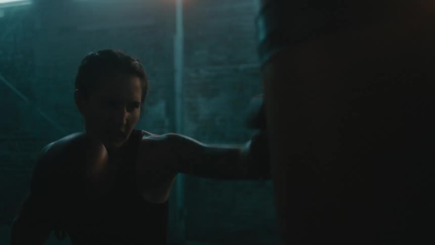A woman is boxing in a room in a building