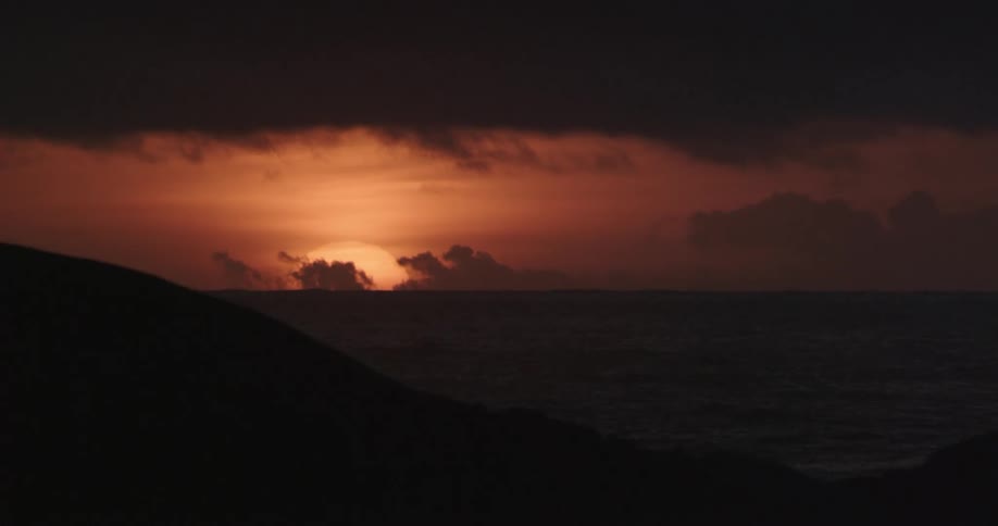 The sun sets over the ocean horizon