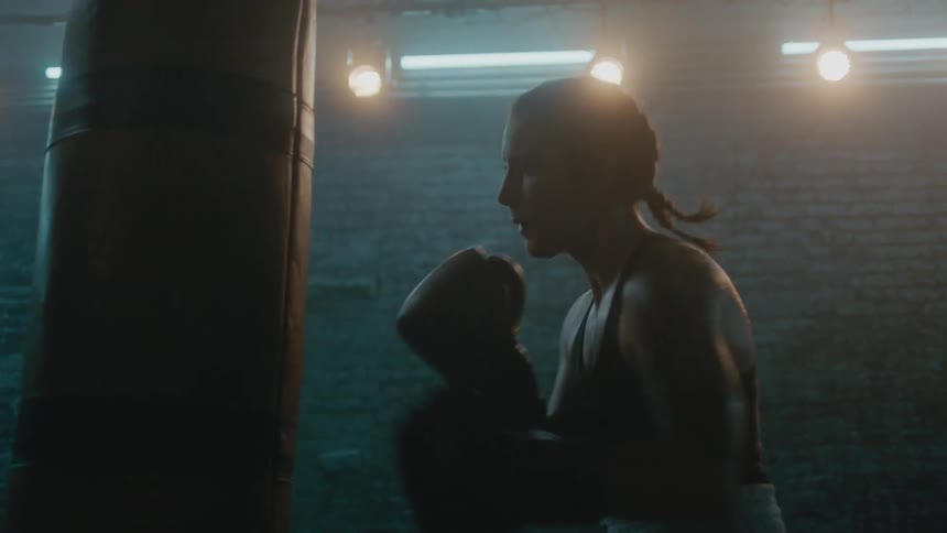 A woman is boxing by herself in a room