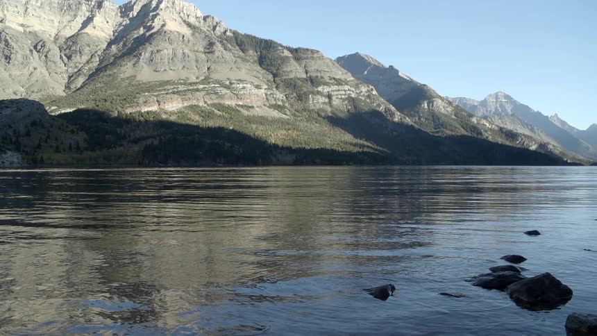 A calm lake sits before a mountain range
