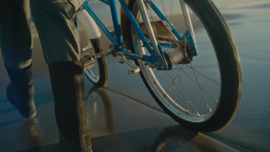 A person is with their bike on the beach