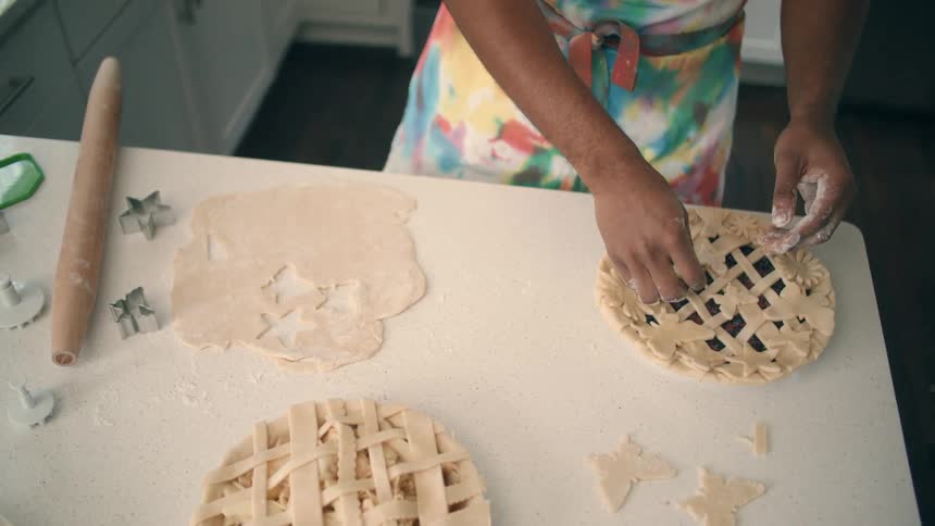 A man is in his kitchen and making a pie