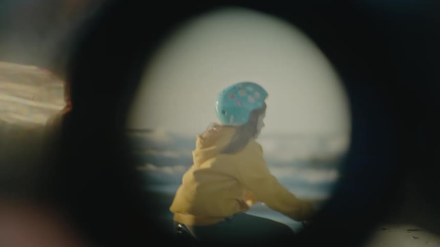 A person rides their bike through the water on the beach