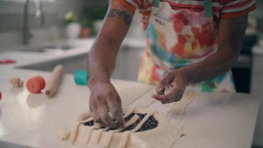 A man is preparing a dessert in his kitchen during the daytime