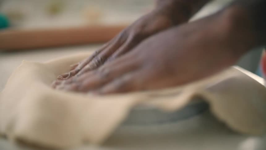 A person is making a pie in their kitchen during midday