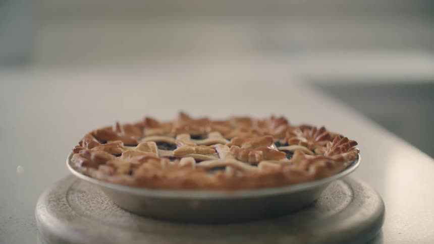 A pie is displayed on a plate on a kitchen counter