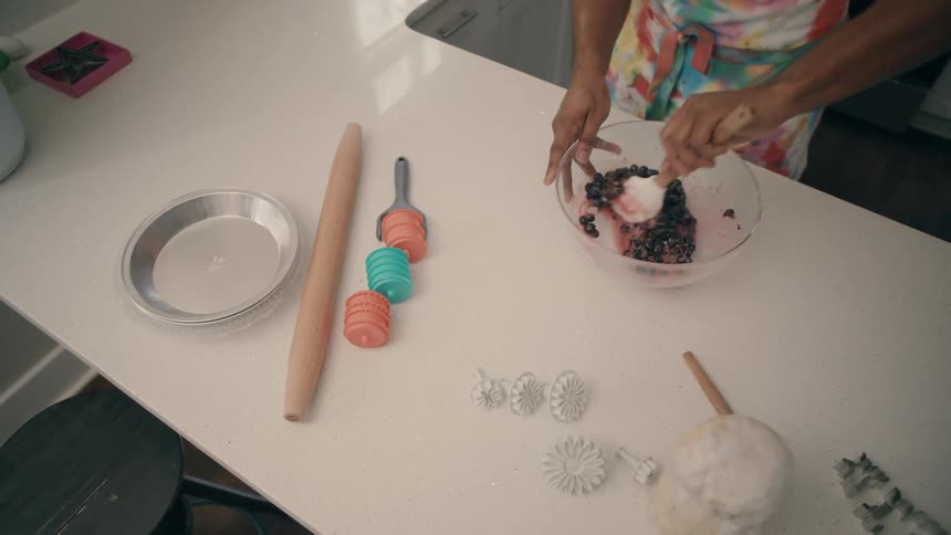 A person is mixing ingredients to make a dessert