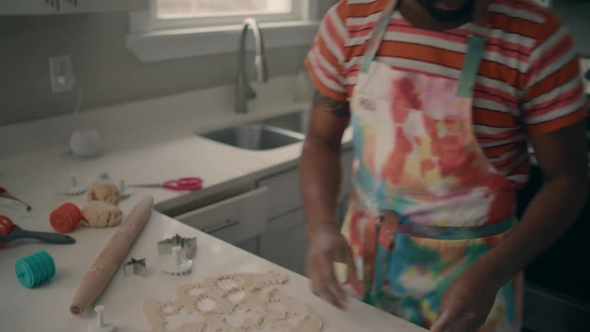 A man is cooking a pie in his kitchen during the day time