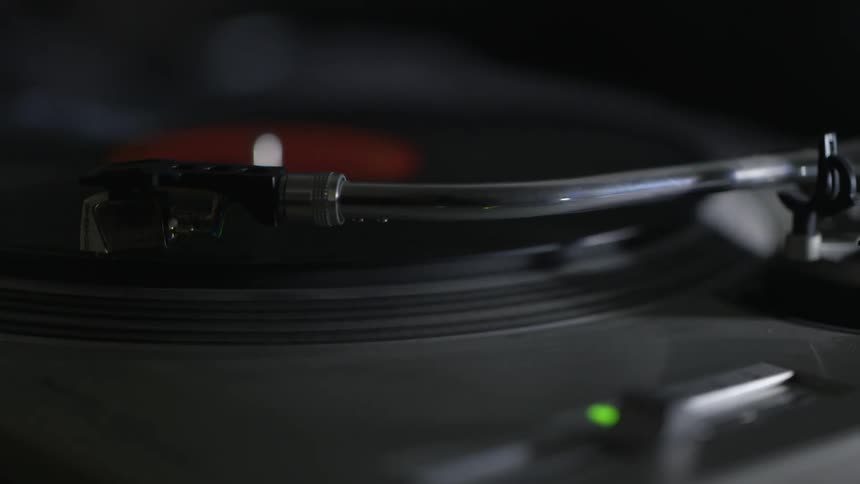 A person starts a record player