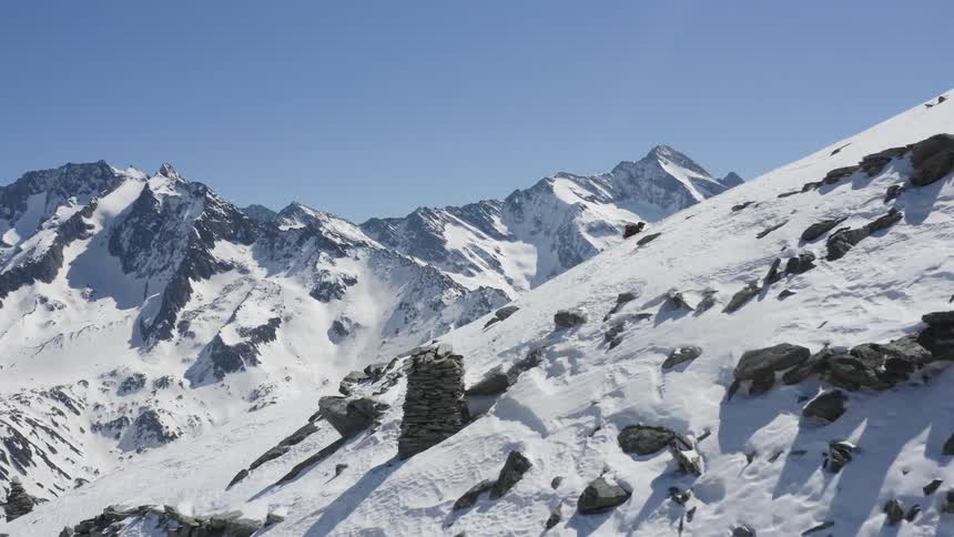 Aerial view of a skier climbing the snow covered slope of a mountain at daytime