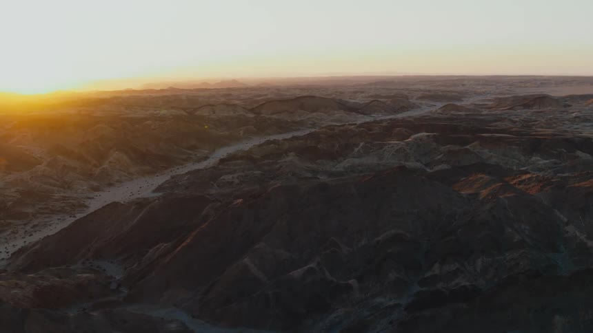 Golden sunset aerial over desert mountains