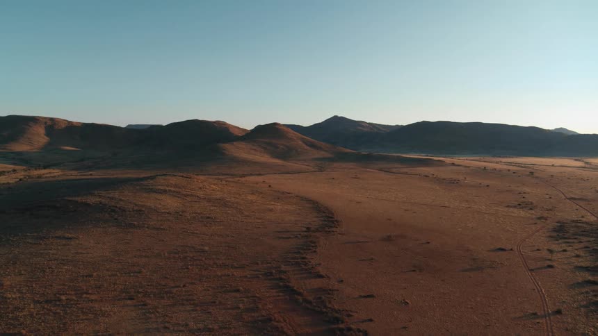 Dramatic desert aerial over pristine grasslands and mountains