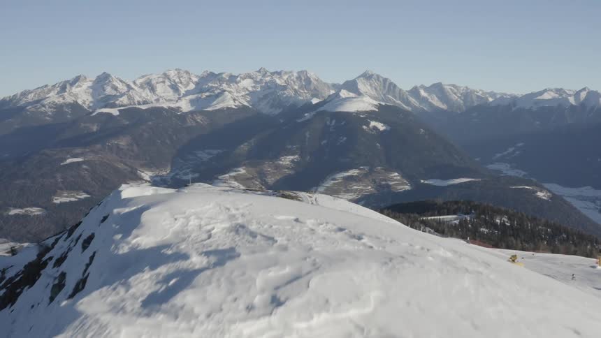 A snow covered mountain with people skiing down it