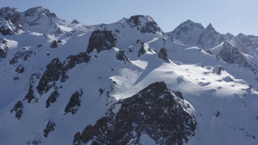The summit of a mountain covered in snow during the day