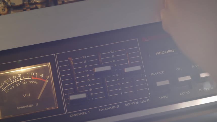 A person is pressing buttons and turning knobs on a machine