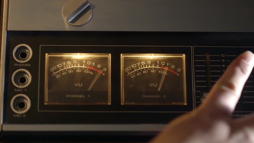 A hand adjusts dials on a machine