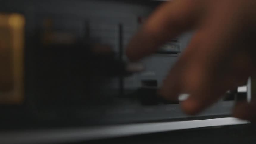 Hand pushes a button on a stereo turning it off