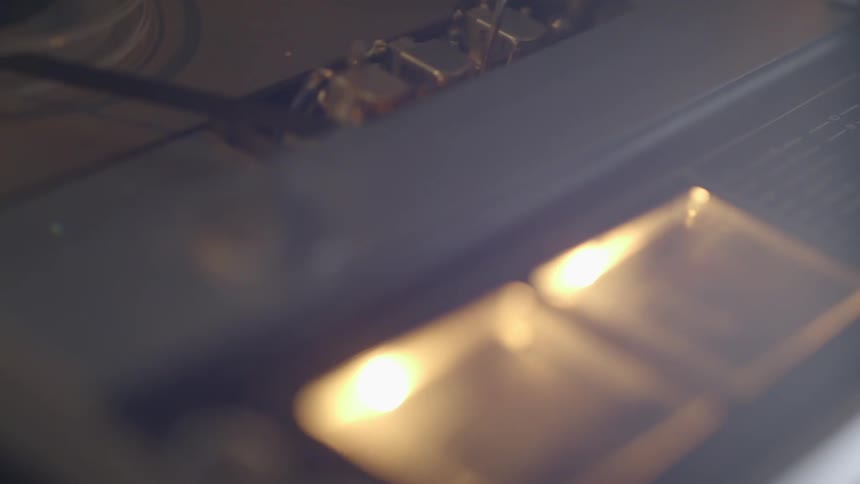 A tape recorder is playing with lit dials