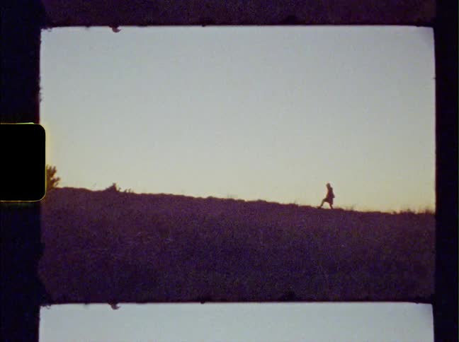The silhouette of a person can be seen a great distance away as they walk uphill