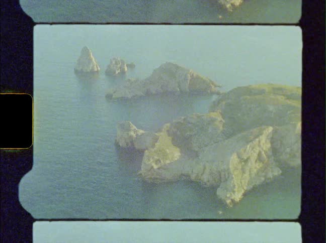 Small islands made of rocks sit close together in the sea