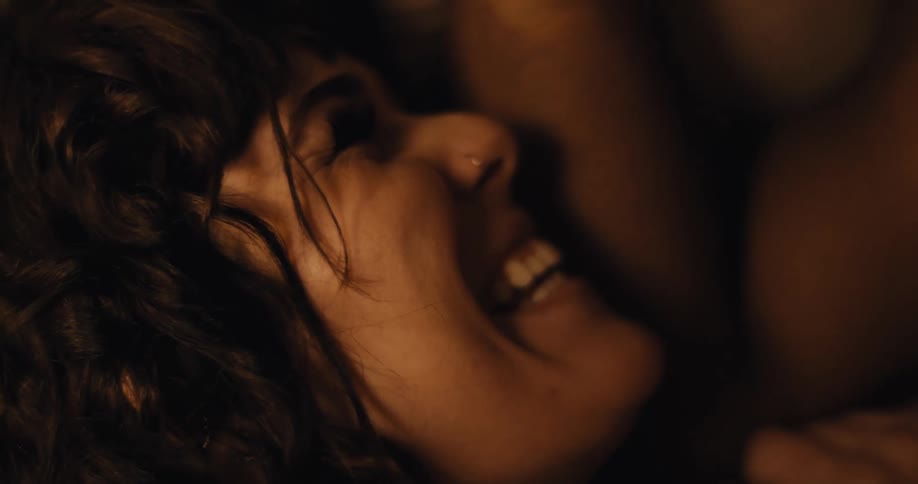 Young happy woman with a nose piercing laughing while laying next to her couple