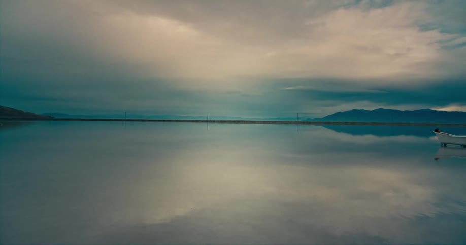 A woman lies in a bathtub floating in the sea