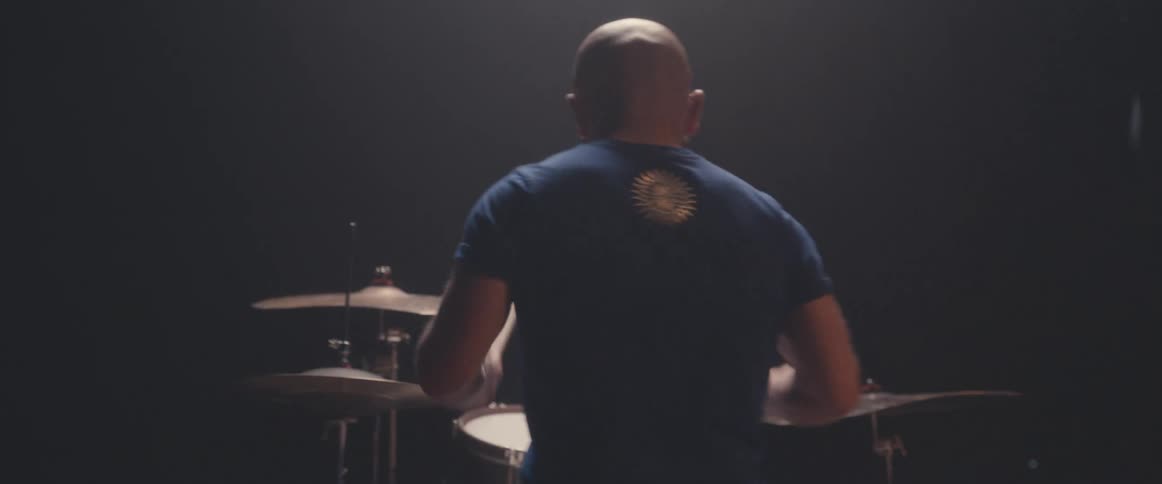 A man is sitting and playing the drums