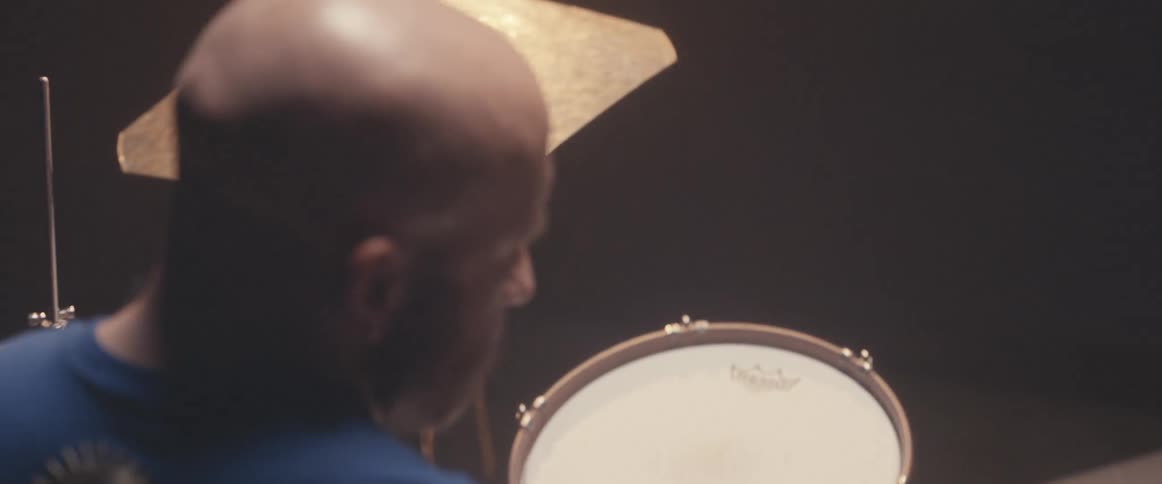 A man is holding drumsticks and playing the drums
