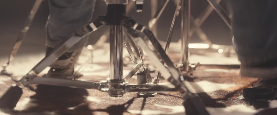 A drummers feet stomping on the drum pedals